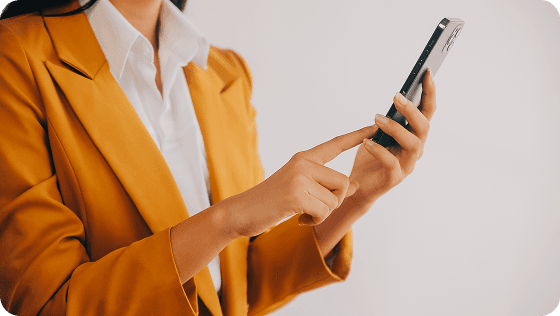 A person in a mustard blazer holding a phone